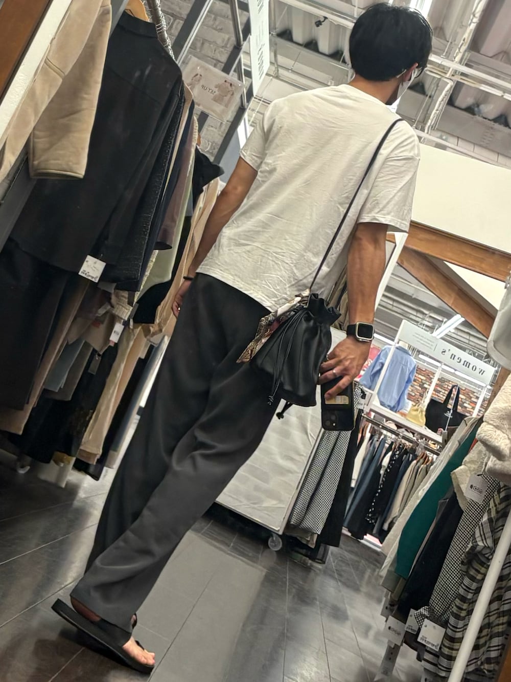 グレー系のスラックス、ブラック系のサンダル、ホワイト系のTシャツ/カットソーを着用したメンズの夏コーディネートの2枚目の写真