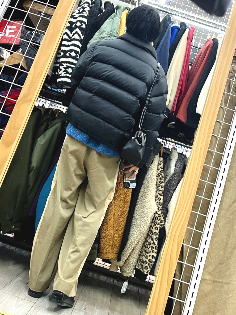 ブラック系のダウンジャケット/コート、ブルー系のニット/セーター、ベージュ系のパンツを着用したメンズの冬コーディネートの2枚目の写真