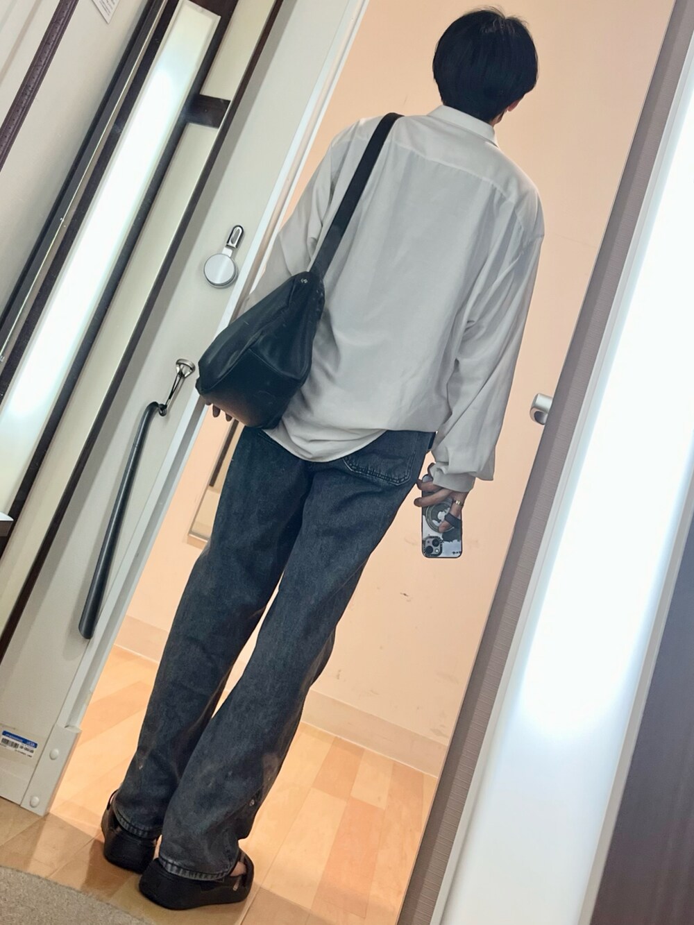 ブラック系のサンダル、グレー系のシャツ/ブラウス、ブラック系のショルダーバッグを着用したメンズの夏コーディネートの2枚目の写真