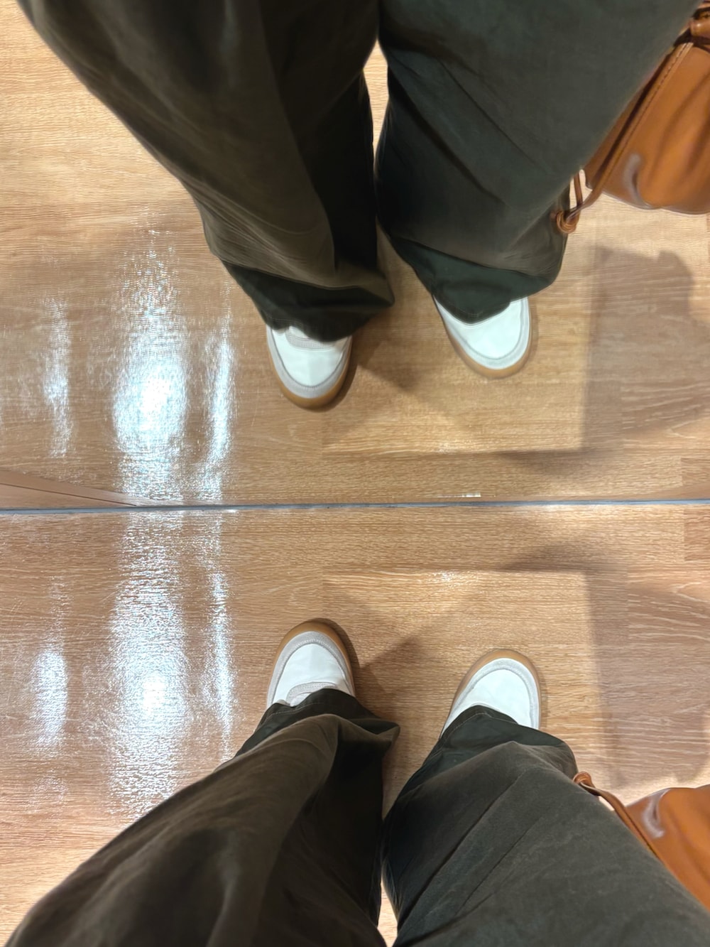 ホワイト系のスニーカー、ブラック系のニット/セーター、ブルー系のデニムジャケットを着用したメンズの秋コーディネートの5枚目の写真