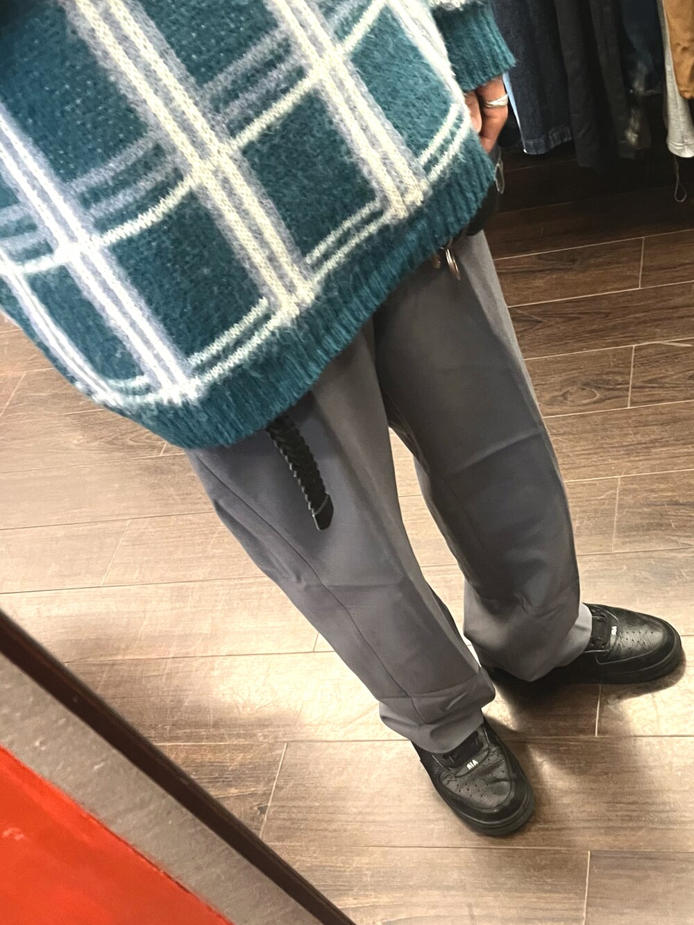 グレー系のパンツ、ブラック系のスニーカー、グリーン系のニット/セーターを着用したメンズの冬コーディネートの3枚目の写真