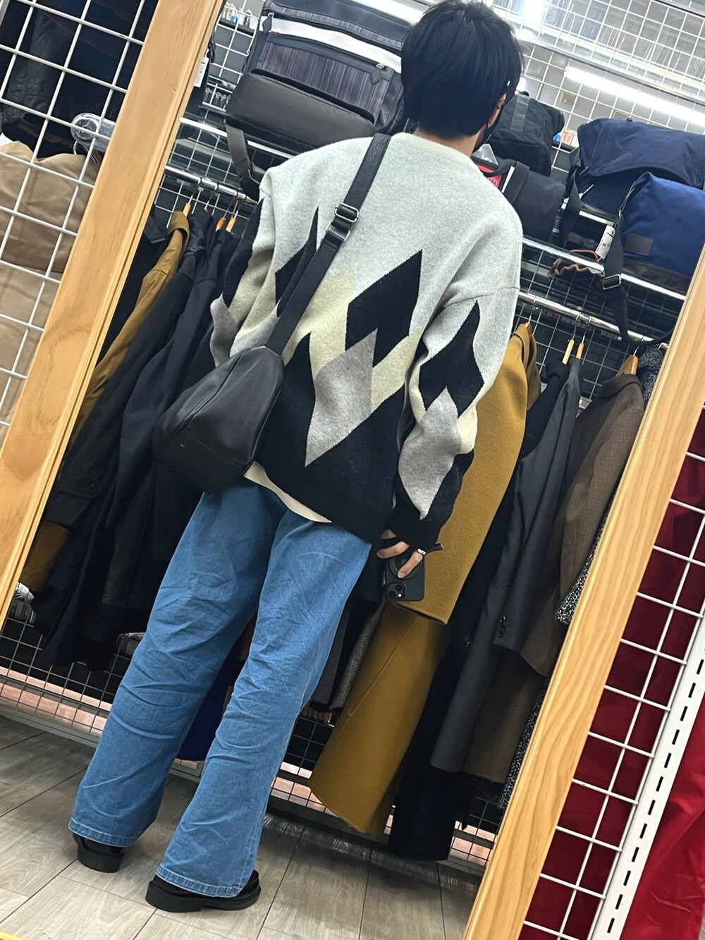 ブルー系のデニムパンツ、ブラック系のローファー、ホワイト系のニット/セーターを着用したメンズの冬コーディネートの2枚目の写真