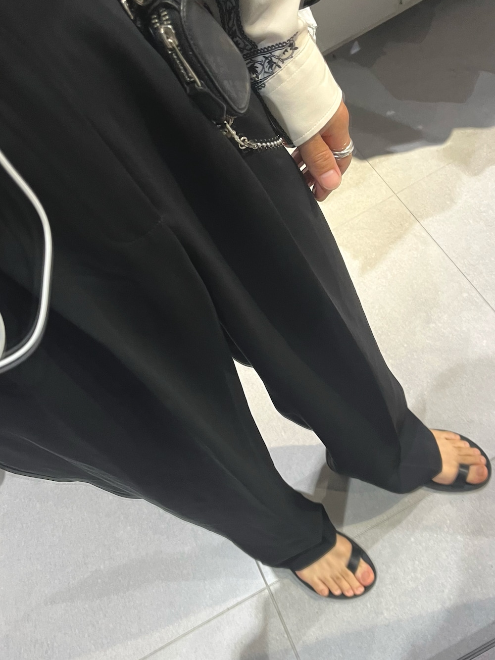 ブラック系のスラックス、ブラック系のサンダル、ブラック系のショルダーバッグを着用したメンズの秋コーディネートの3枚目の写真