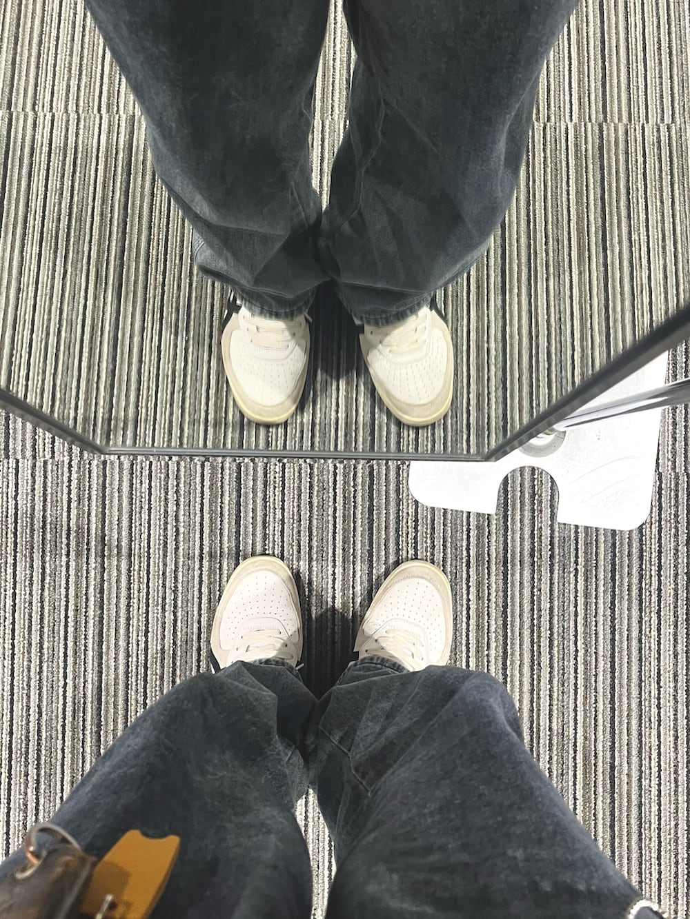 グレー系のデニムパンツ、ホワイト系のスニーカー、ホワイト系のニット/セーターを着用したメンズの春コーディネートの5枚目の写真