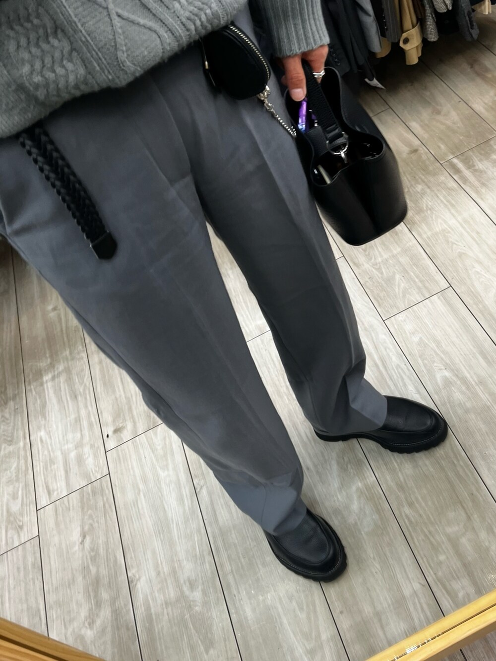 グレー系のパンツ、ブラック系のドレスシューズ、ブラック系のショルダーバッグを着用したメンズの冬コーディネートの3枚目の写真