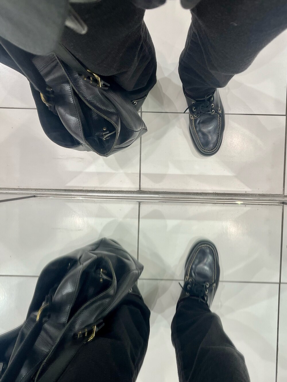 ブラック系のパンツ、ブラック系のローファー、グレー系のテーラードジャケットを着用したメンズの冬コーディネートの5枚目の写真