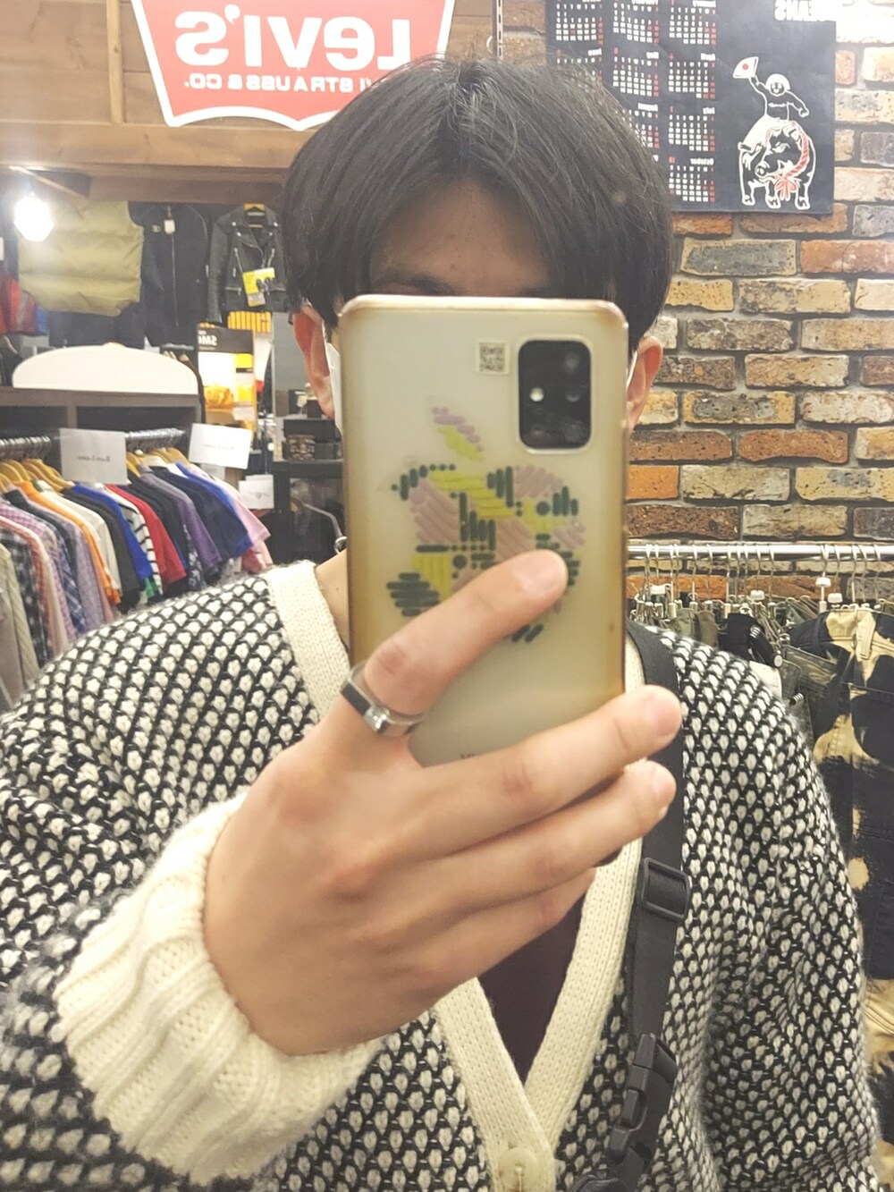 ブラック系のパンツ、ブラック系のスニーカー、ホワイト系のカーディガン/ボレロを着用したメンズの春コーディネートの4枚目の写真