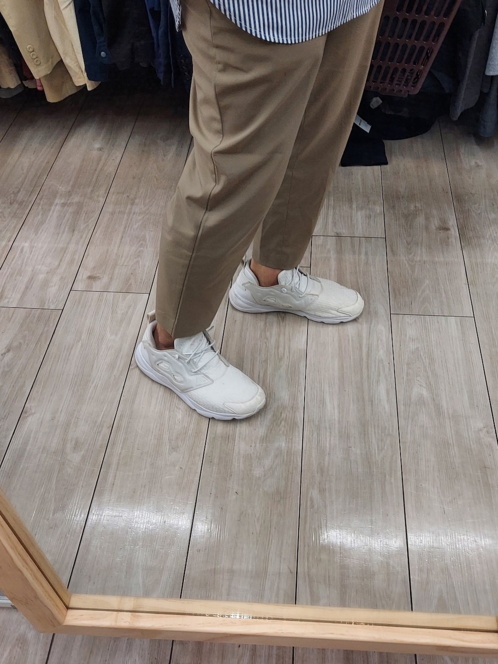 グレー系のベスト、ブラウン系のボディバッグ/ウエストポーチ、ベージュ系のスラックスを着用したメンズの春コーディネートの3枚目の写真