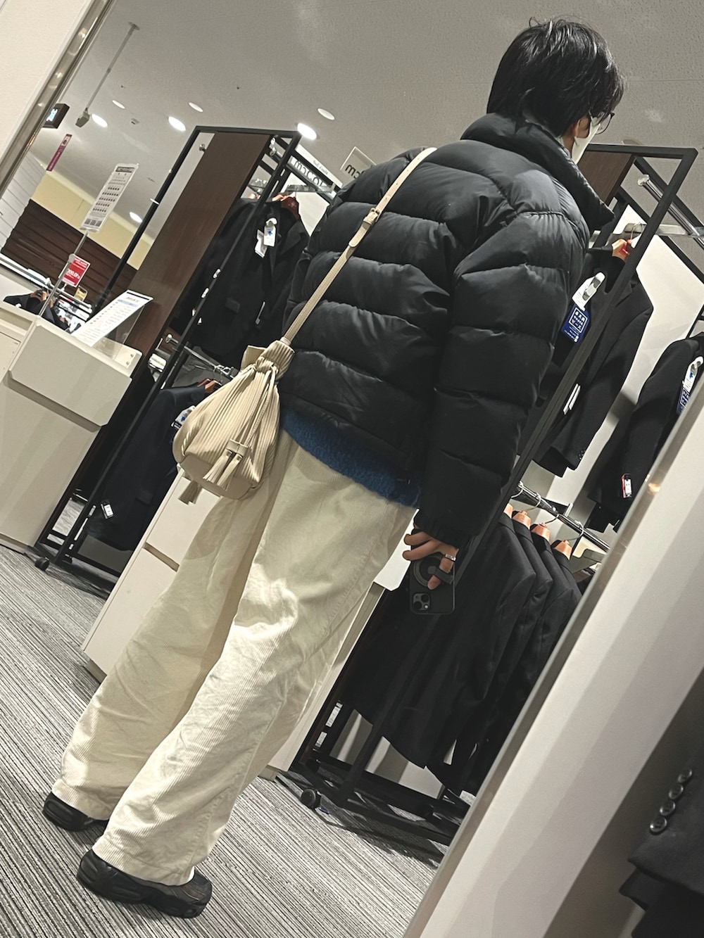 ホワイト系のパンツ、ブラック系のスニーカー、ブラック系のダウンジャケット/コートを着用したメンズの冬コーディネートの2枚目の写真