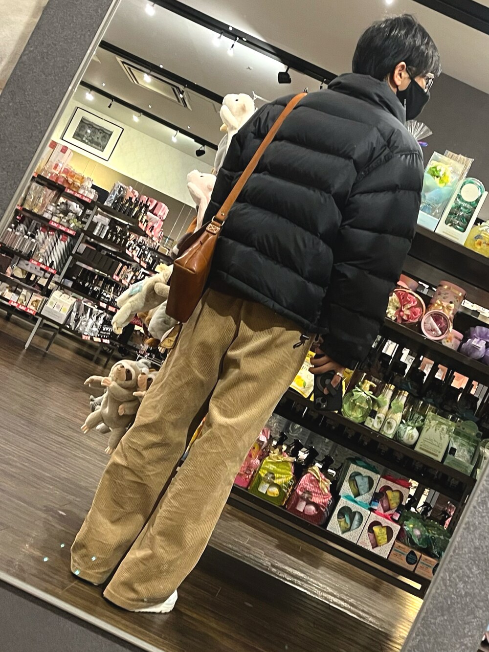 ブラウン系のパンツ、ホワイト系のスニーカー、ブラウン系のボディバッグ/ウエストポーチを着用したメンズの冬コーディネートの2枚目の写真