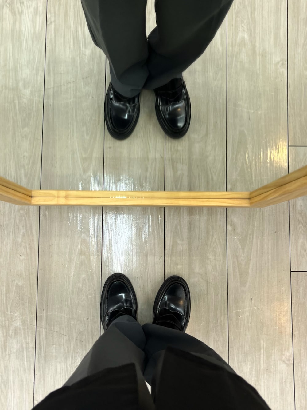 ブルー系のパンツ、ブラック系のローファー、ブラック系のベストを着用したメンズの秋コーディネートの5枚目の写真