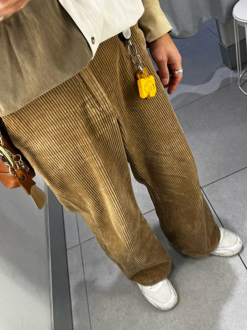 ブラウン系のパンツ、ホワイト系のスニーカー、ベージュ系のシャツ/ブラウスを着用したメンズの冬コーディネートの3枚目の写真