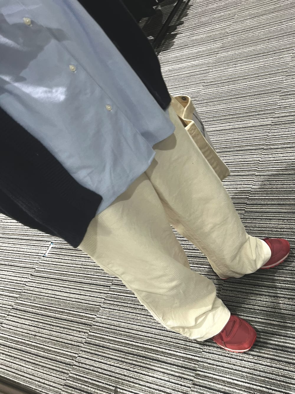 レッド系のスニーカー、ホワイト系のパンツ、ベージュ系のショルダーバッグを着用したメンズの春コーディネートの3枚目の写真