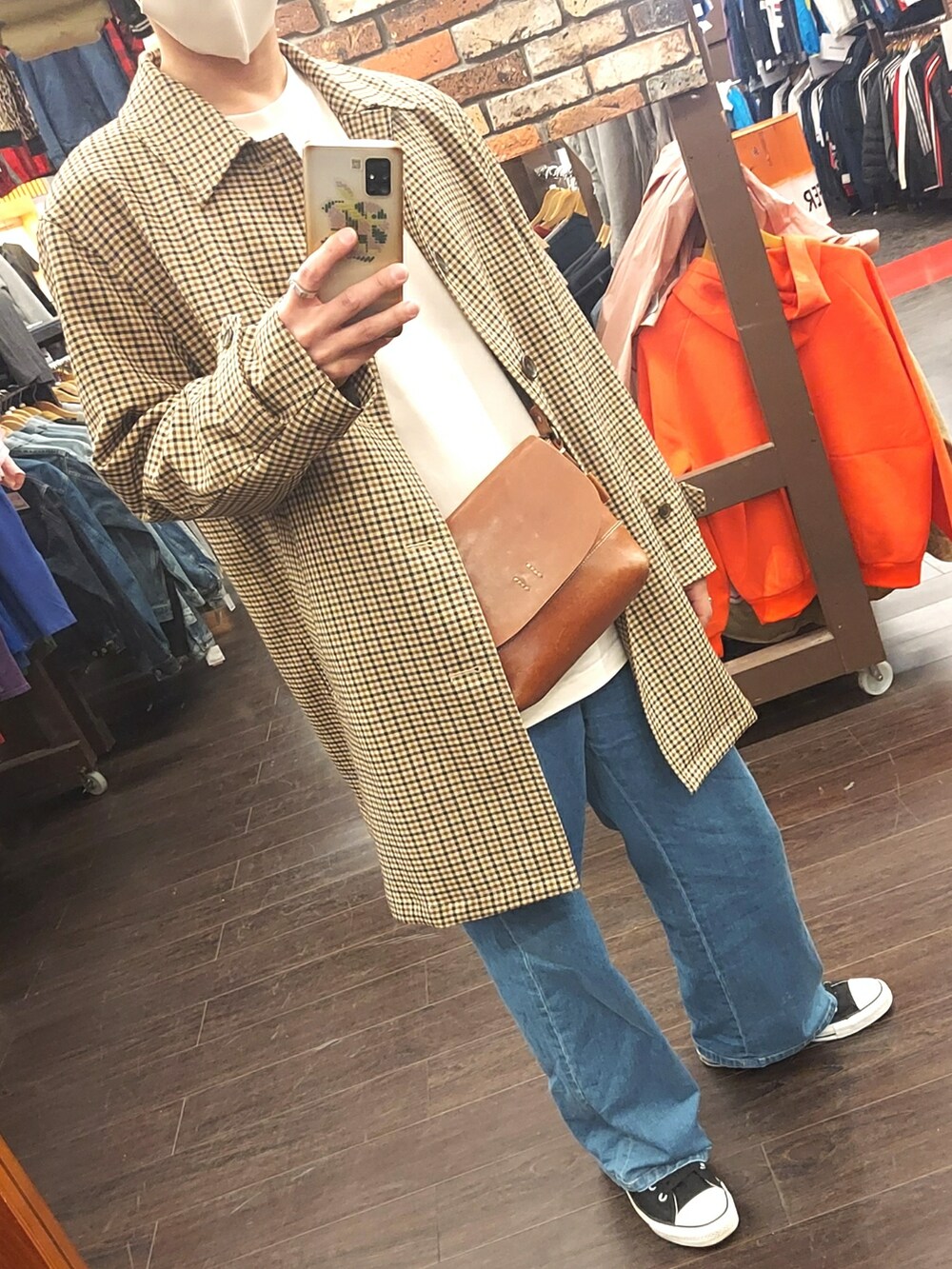 ブルー系のデニムパンツ、ブラック系のスニーカー、ブラウン系のボディバッグ/ウエストポーチを着用したメンズの春コーディネートの5枚目の写真