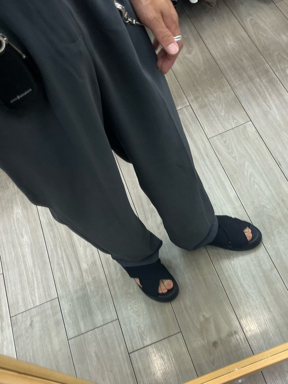 ブラック系のサンダル、グレー系のスラックス、ブラック系のショルダーバッグを着用したメンズの夏コーディネートの3枚目の写真