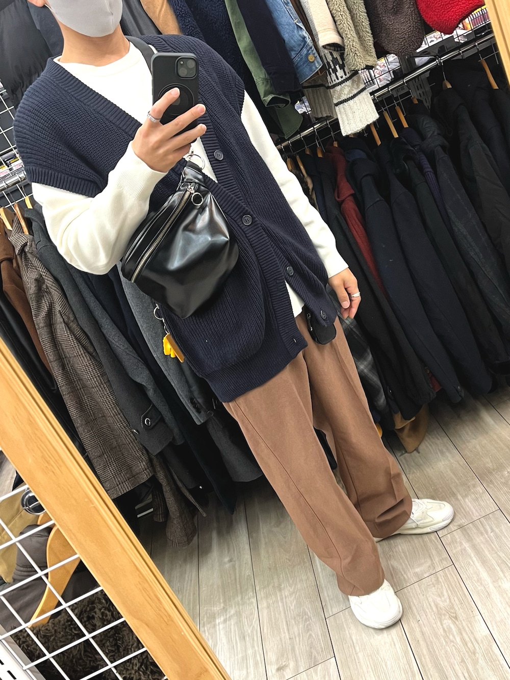 ブラウン系のパンツ、ホワイト系のスニーカー、ブラック系のショルダーバッグを着用したメンズの秋コーディネートの5枚目の写真