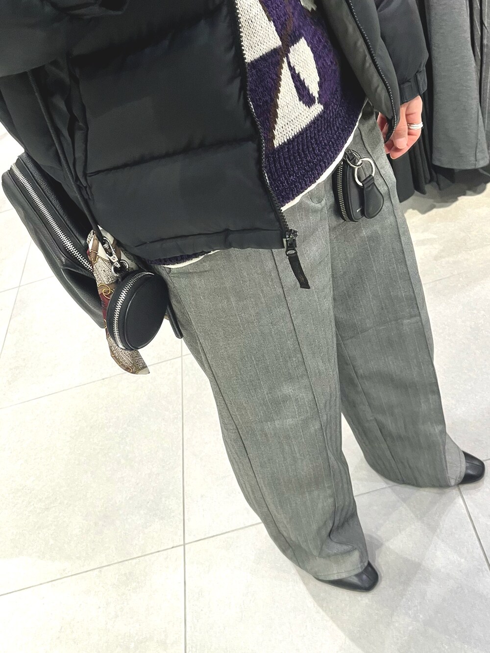 グレー系のスラックス、ブラック系のドレスシューズ、パープル系のニット/セーターを着用したメンズの冬コーディネートの3枚目の写真