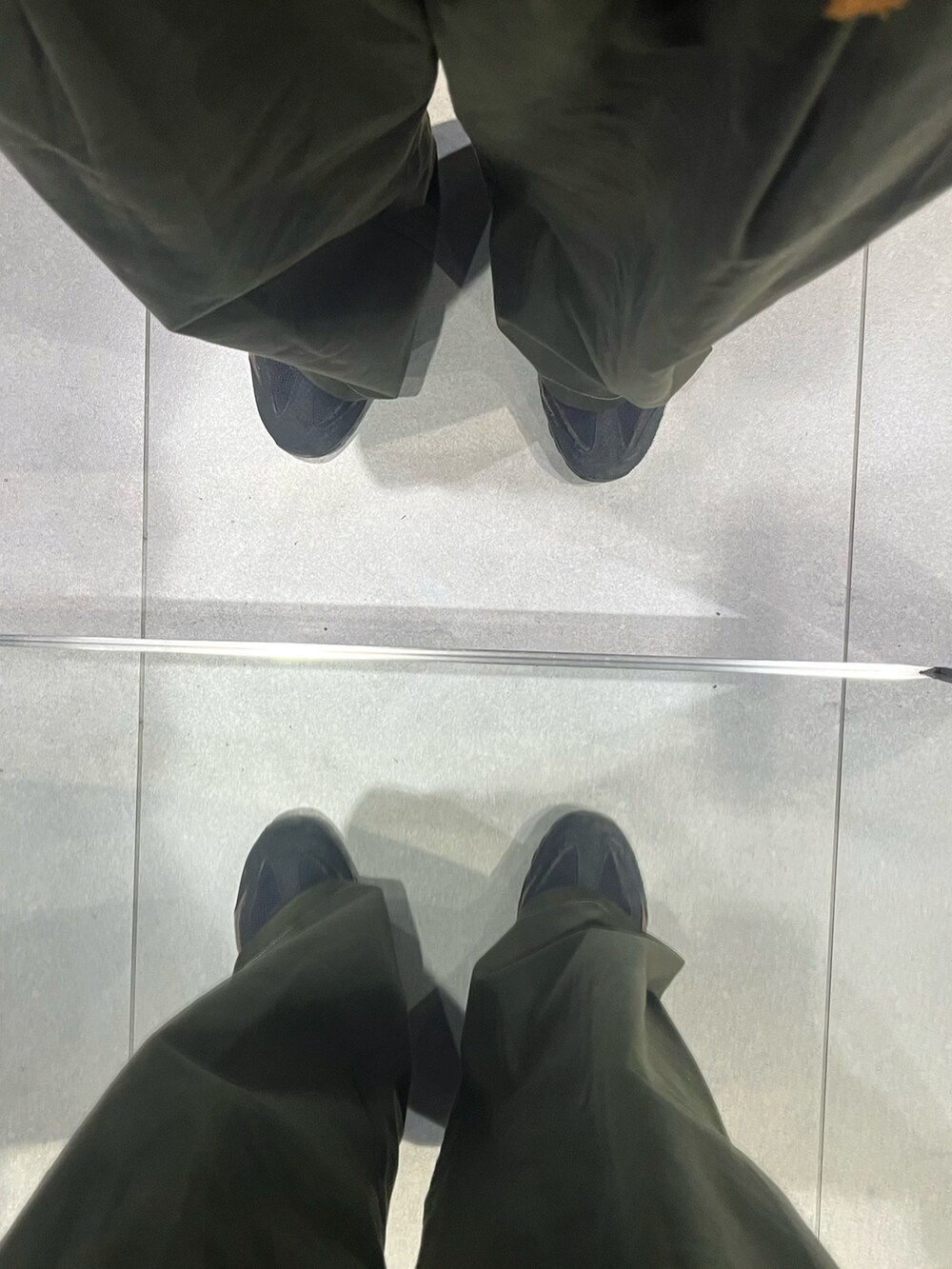 グリーン系のパンツ、ブラック系のスニーカー、ブルー系のシャツ/ブラウスを着用したメンズの秋コーディネートの5枚目の写真