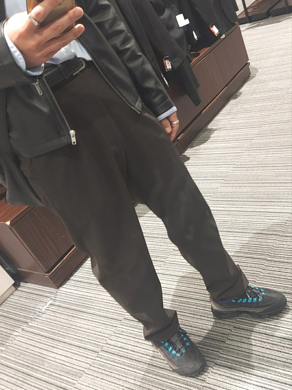 ブラウン系のパンツ、ブラック系のスニーカー、ブラック系のライダースジャケットを着用したメンズの春コーディネートの3枚目の写真