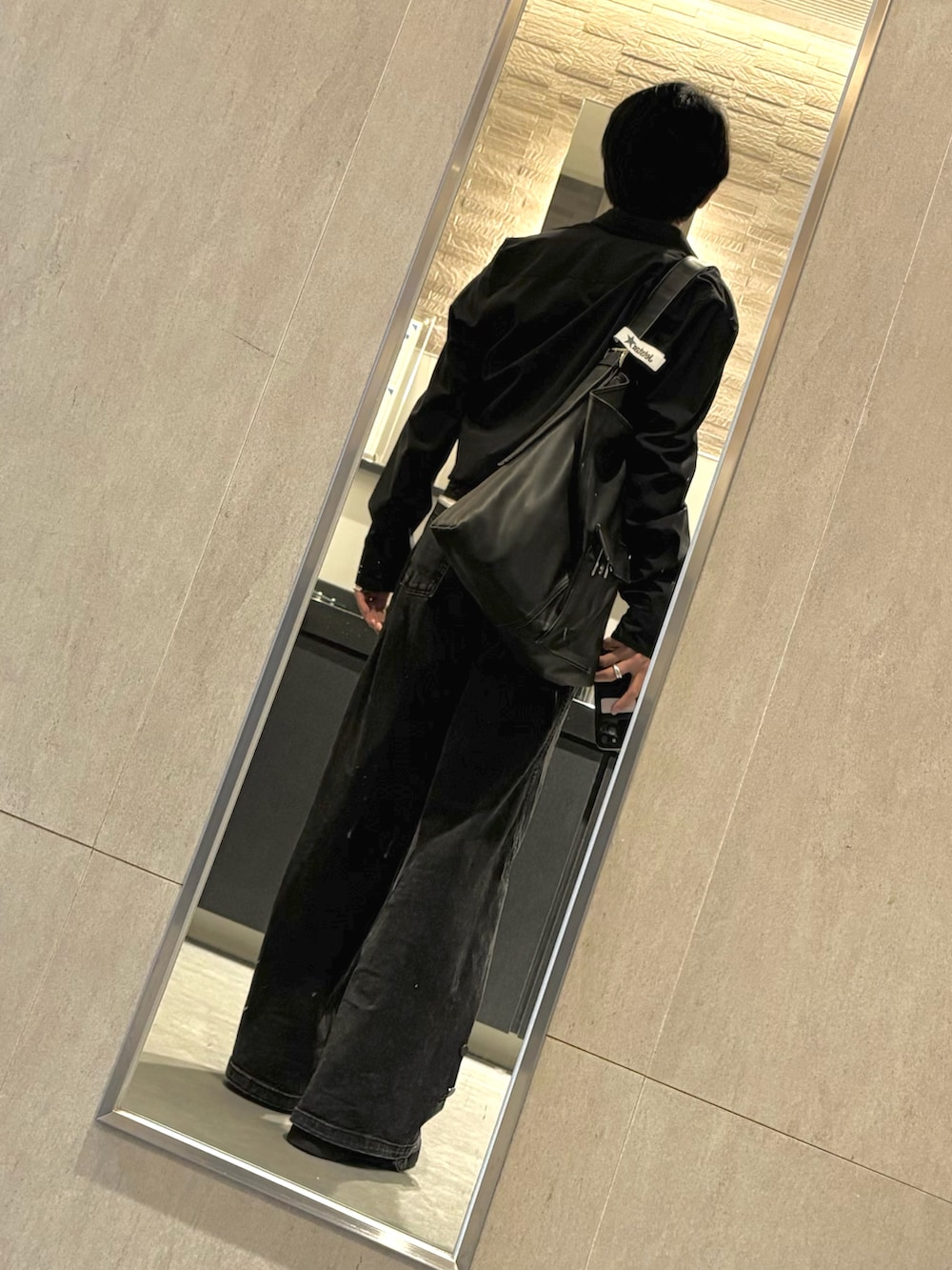 ブラック系のドレスシューズ、ブラック系のシャツ/ブラウス、ブラック系のデニムパンツを着用したメンズの春コーディネートの2枚目の写真