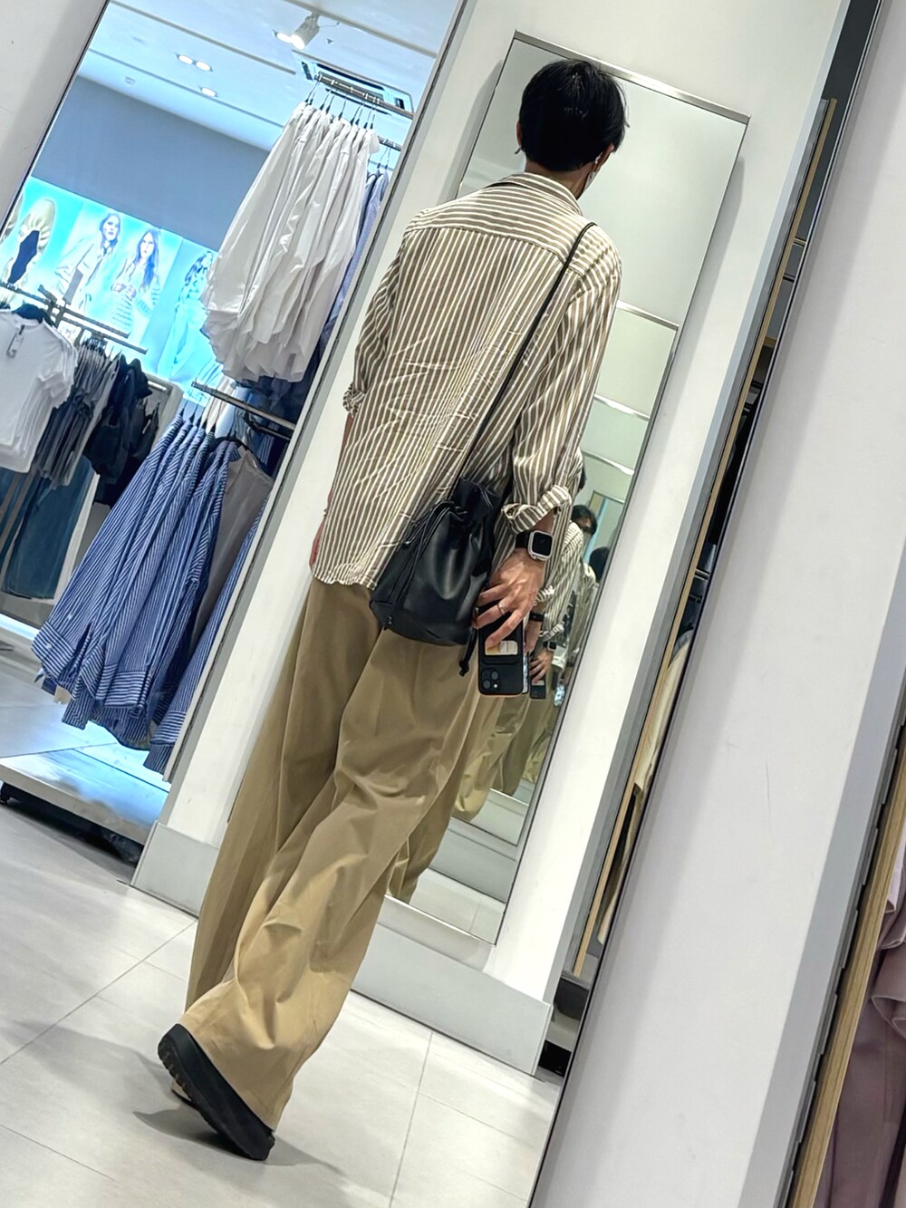 ベージュ系のチノパンツ、ブラック系のサンダル、ホワイト系のTシャツ/カットソーを着用したメンズの夏コーディネートの2枚目の写真