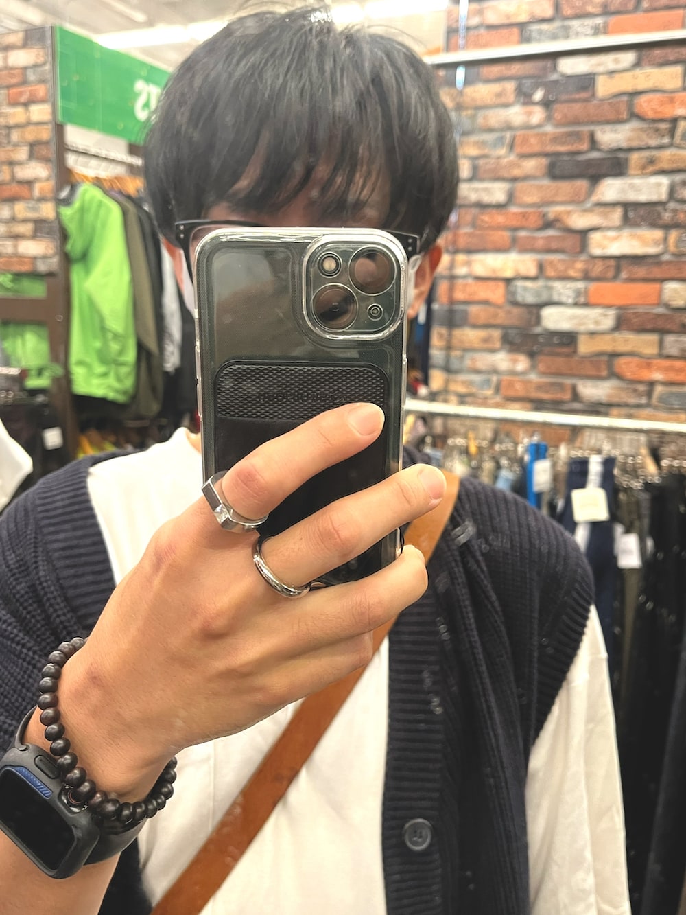 ホワイト系のスニーカー、ブラウン系のパンツ、ブルー系のベストを着用したメンズの秋コーディネートの4枚目の写真