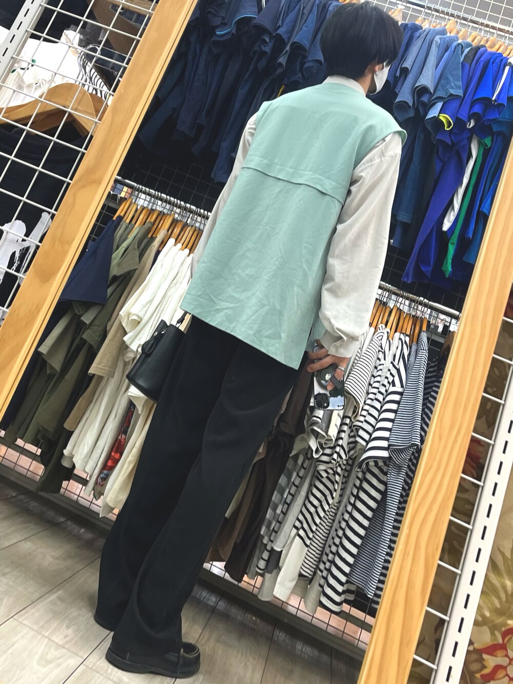 ブラック系のスラックス、ブラック系のローファー、ブラック系のショルダーバッグを着用したメンズの夏コーディネートの2枚目の写真