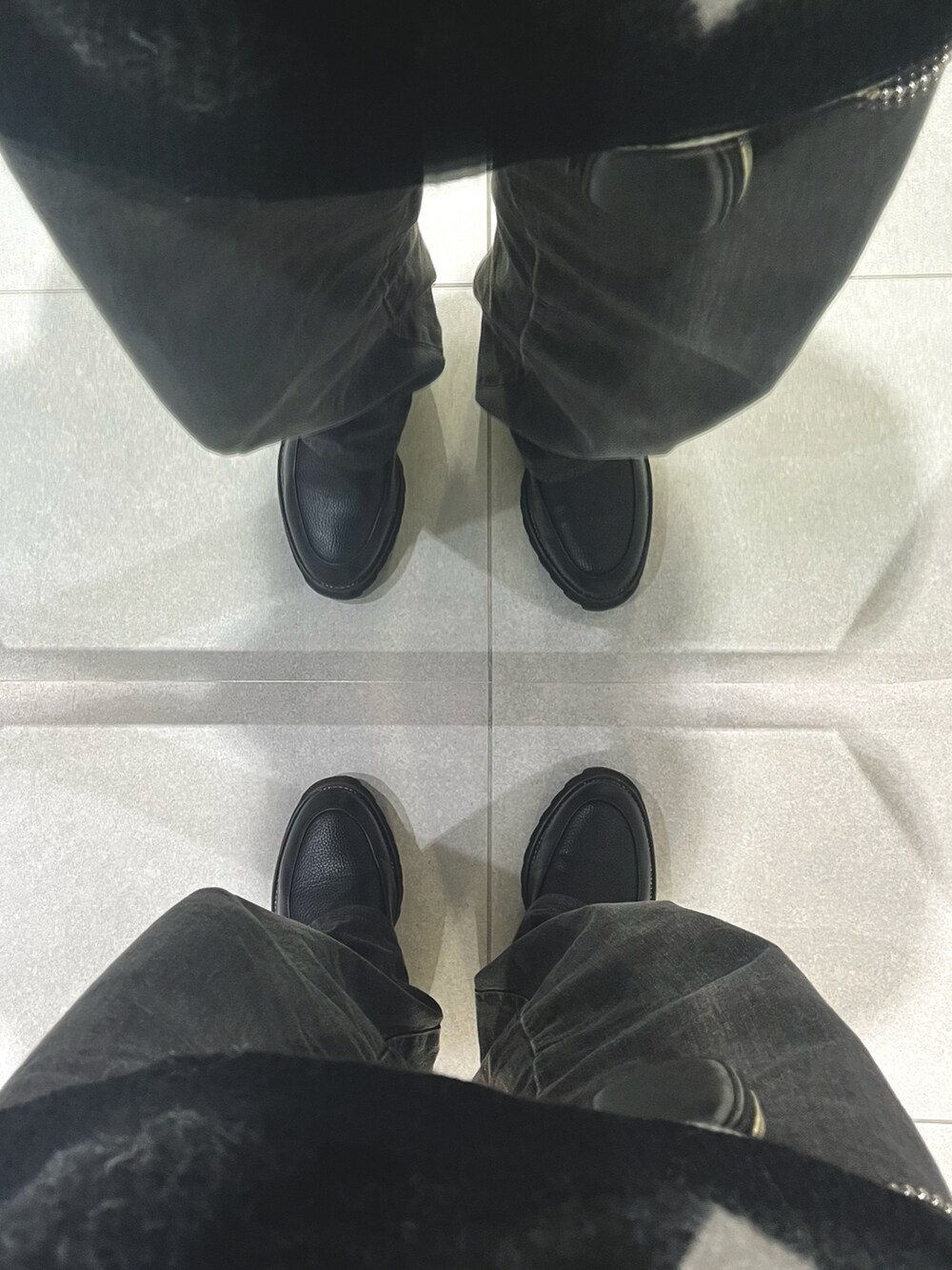 ブラック系のパンツ、ブラック系のドレスシューズ、ホワイト系のニット/セーターを着用したメンズの冬コーディネートの5枚目の写真