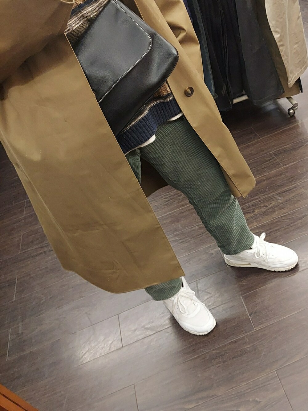 ホワイト系のスニーカー、ブラック系のバッグ、グリーン系のパンツを着用したメンズの冬コーディネートの3枚目の写真