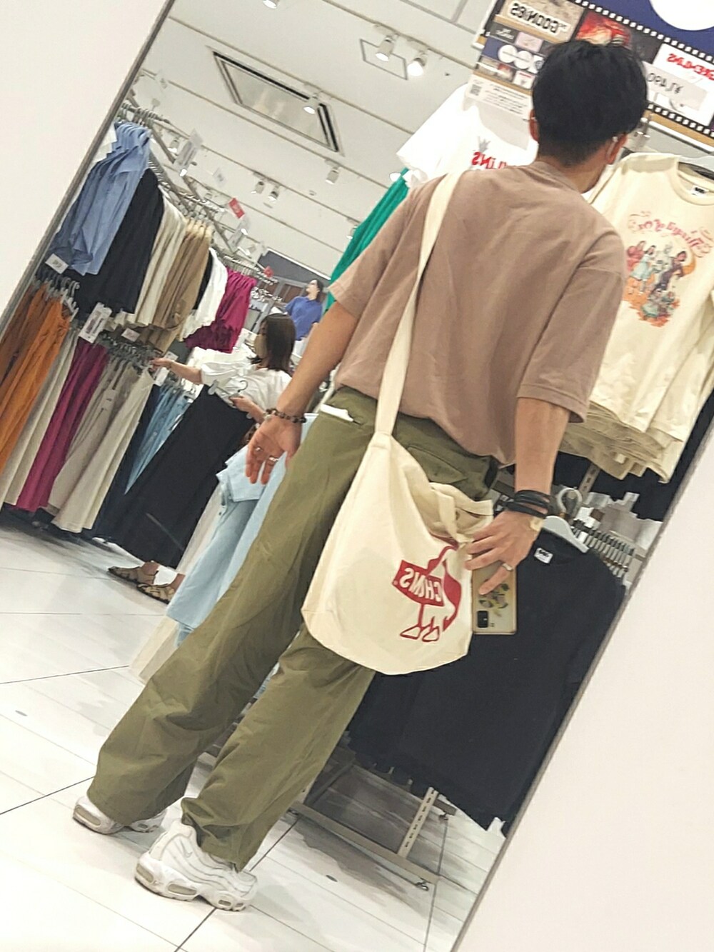 グリーン系のパンツ、ホワイト系のスニーカー、ベージュ系のバッグを着用したメンズの夏コーディネートの2枚目の写真
