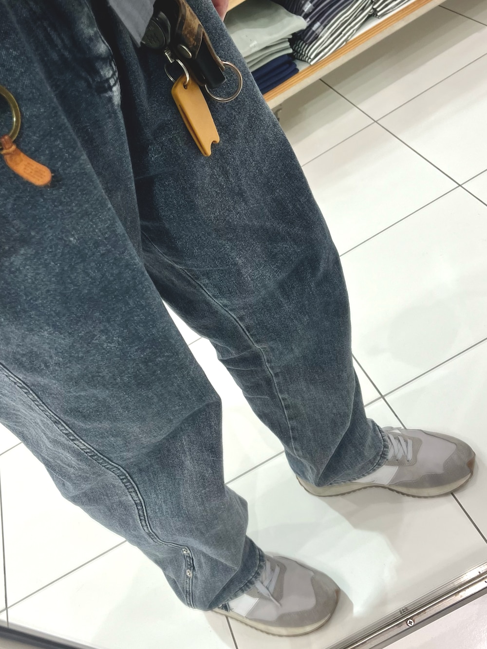 グレー系のデニムパンツ、グレー系のスニーカー、ブラック系のショルダーバッグを着用したメンズの春コーディネートの3枚目の写真