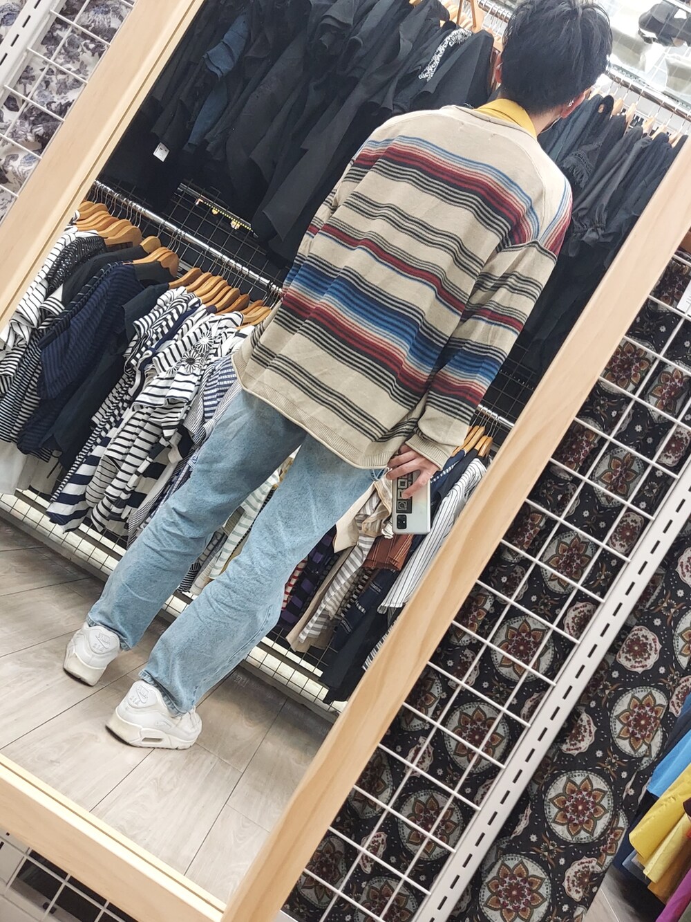 ブルー系のデニムパンツ、ホワイト系のスニーカー、ブラック系のショルダーバッグを着用したメンズの春コーディネートの3枚目の写真