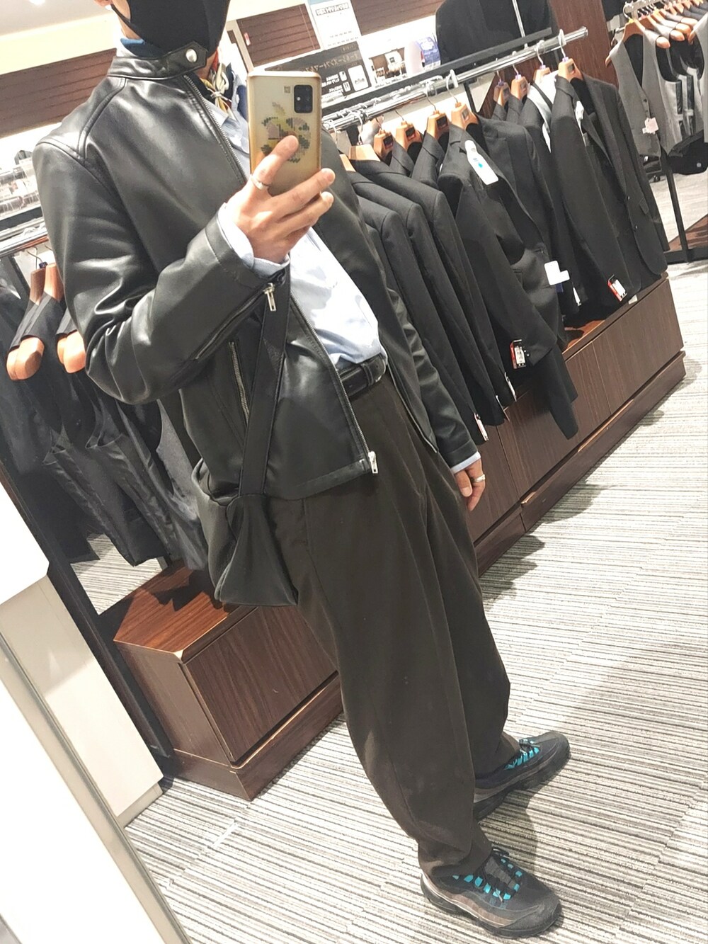 ブラウン系のパンツ、ブラック系のスニーカー、ブラック系のライダースジャケットを着用したメンズの春コーディネートの5枚目の写真