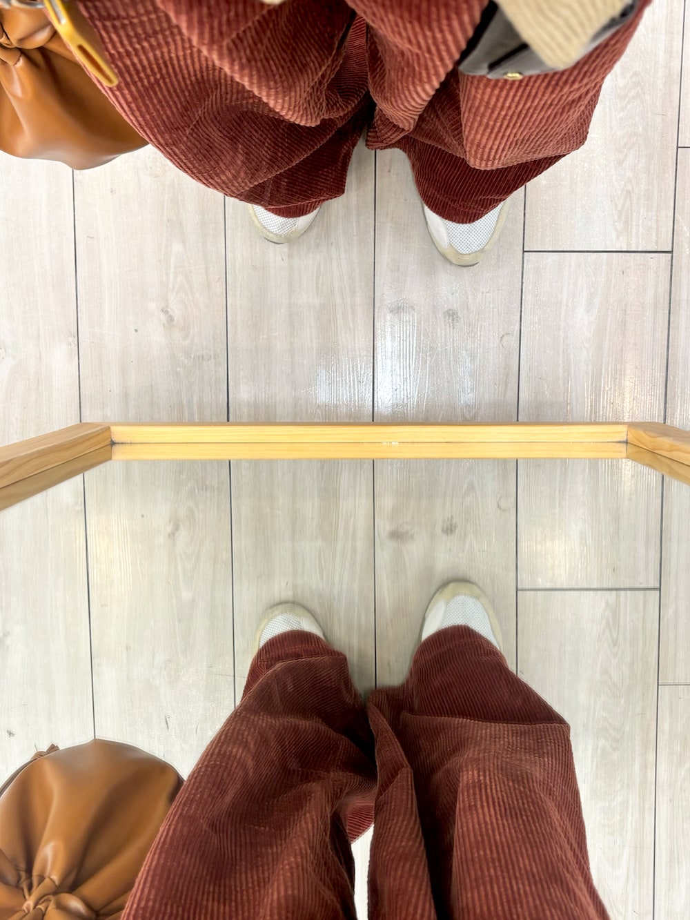 ブラウン系のショルダーバッグ、ブラウン系のカーディガン/ボレロ、レッド系のその他パンツを着用したメンズの冬コーディネートの5枚目の写真