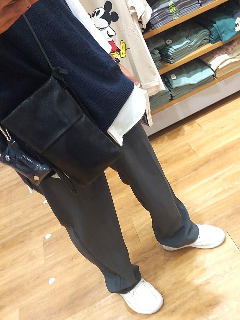 ホワイト系のスニーカー、ブルー系のパンツ、ブルー系のベストを着用したメンズの春コーディネートの3枚目の写真