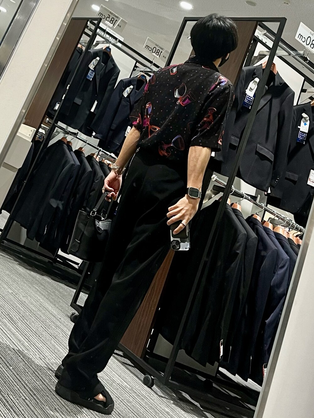 ブラック系のスラックス、ブラック系のサンダル、ブラック系のショルダーバッグを着用したメンズの夏コーディネートの2枚目の写真