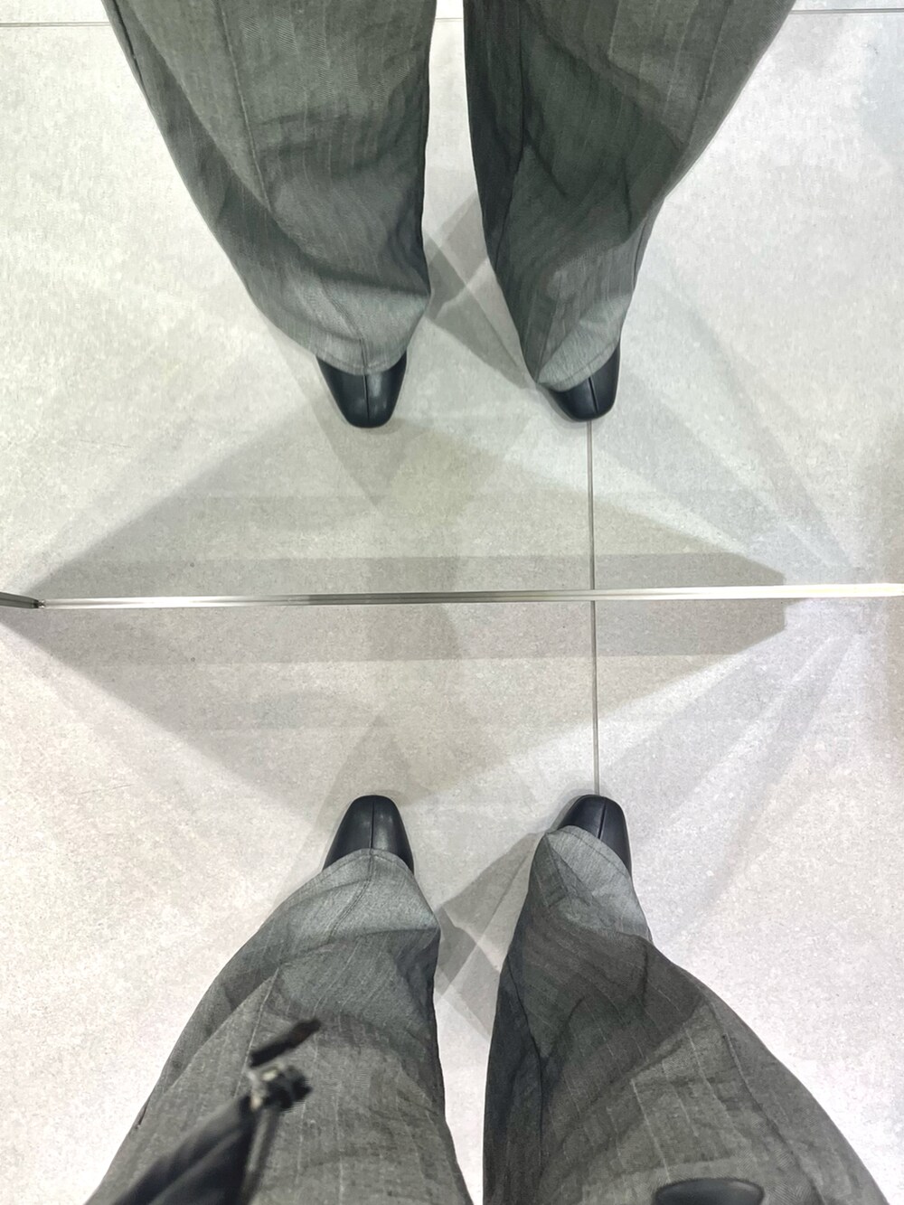 グレー系のスラックス、ブラック系のドレスシューズ、パープル系のニット/セーターを着用したメンズの冬コーディネートの5枚目の写真