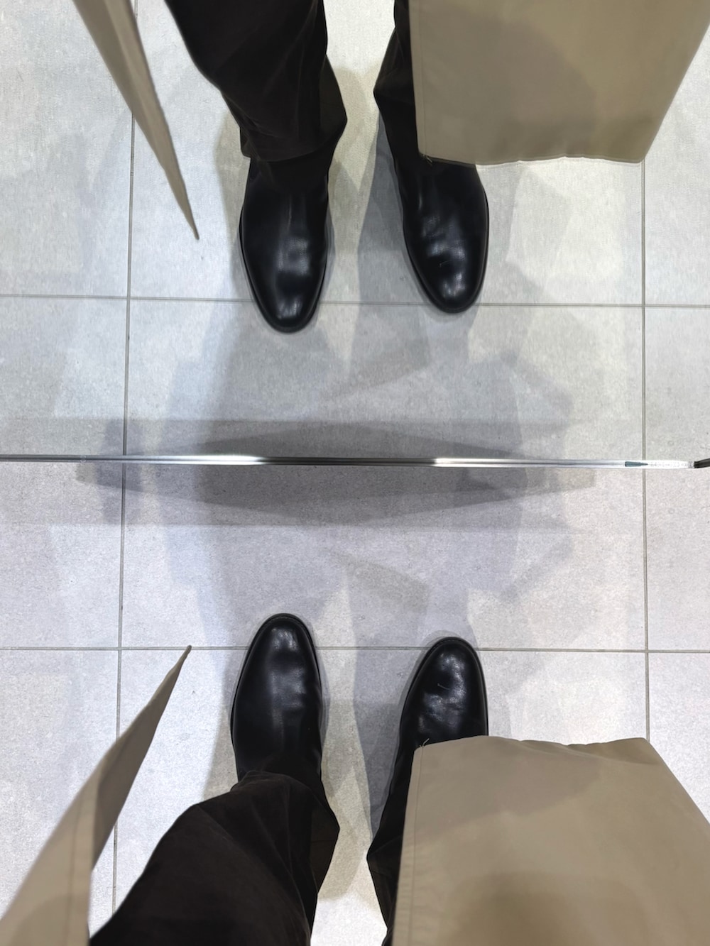 ブルー系のカーディガン/ボレロ、ブラウン系のスラックス、ベージュ系のトレンチコートを着用したメンズの冬コーディネートの5枚目の写真