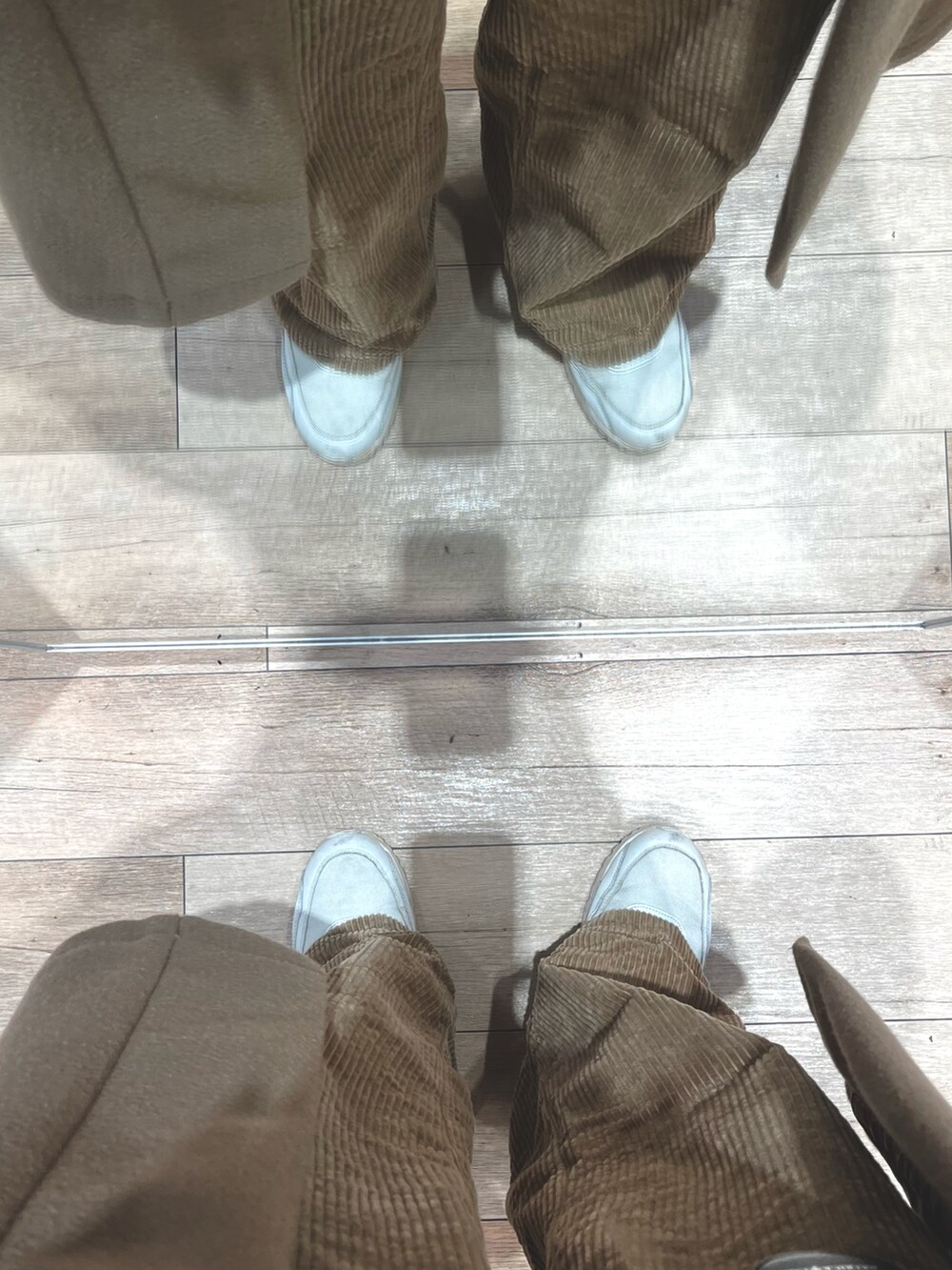 ブラウン系のパンツ、ブラウン系のジャケット/アウター、ホワイト系のスニーカーを着用したメンズの冬コーディネートの5枚目の写真