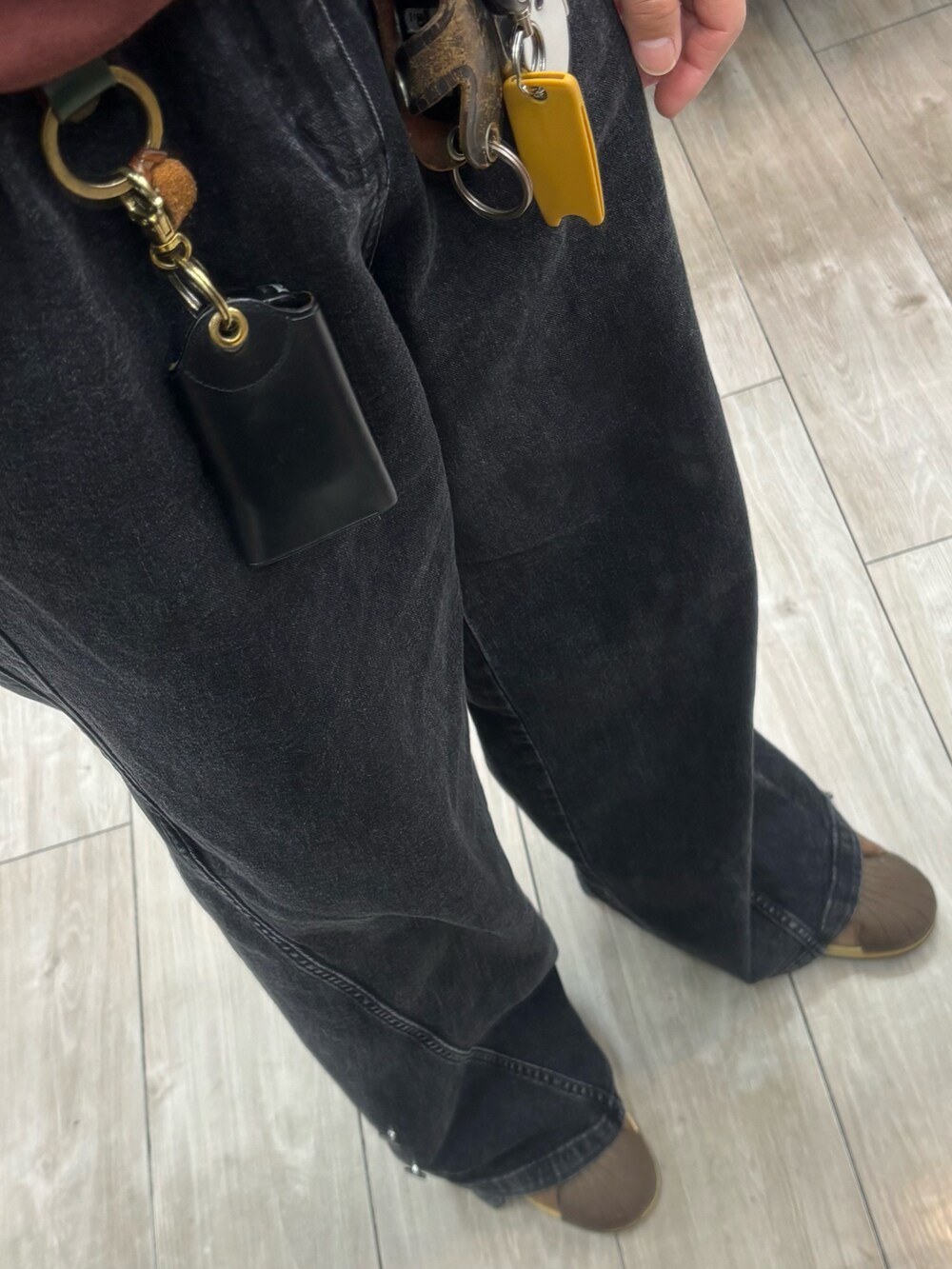 ブラウン系のスウェット、ブルー系のカーディガン/ボレロ、ブラック系のデニムパンツを着用したメンズの春コーディネートの3枚目の写真