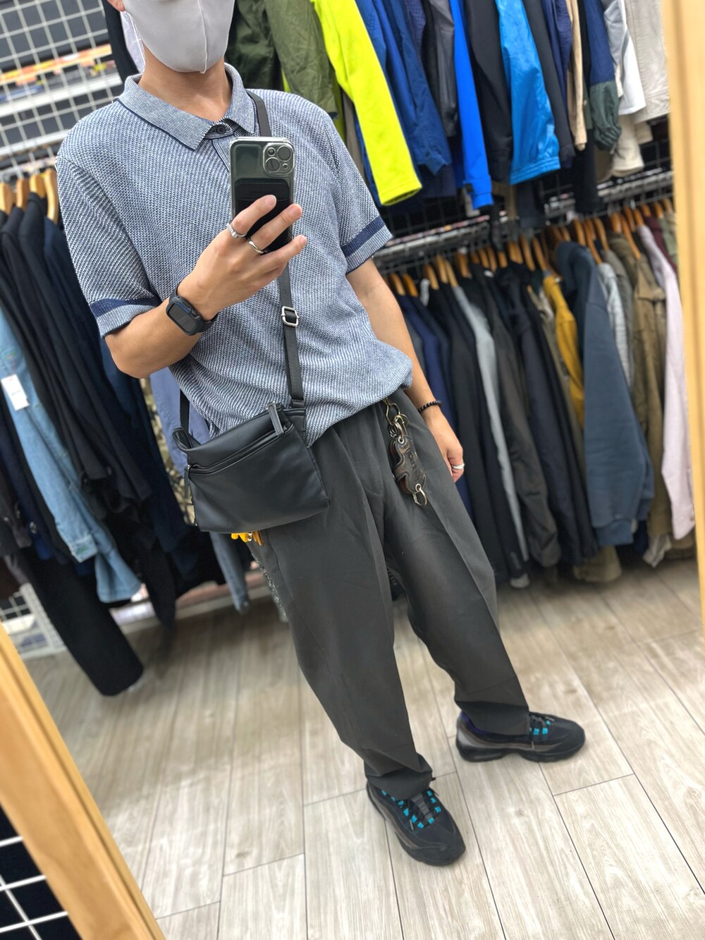 ブラック系のパンツ、ブラック系のスニーカー、ブルー系のポロシャツを着用したメンズの秋コーディネートの5枚目の写真