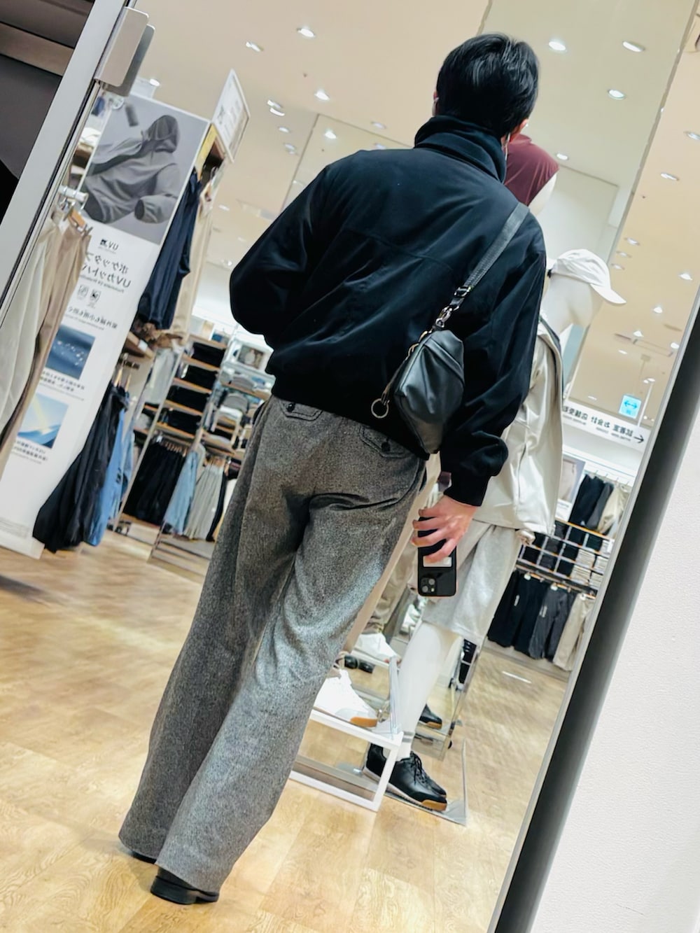 ブラック系のブーツ、ブルー系のジャケット/アウター、グレー系のスラックスを着用したメンズの春コーディネートの2枚目の写真