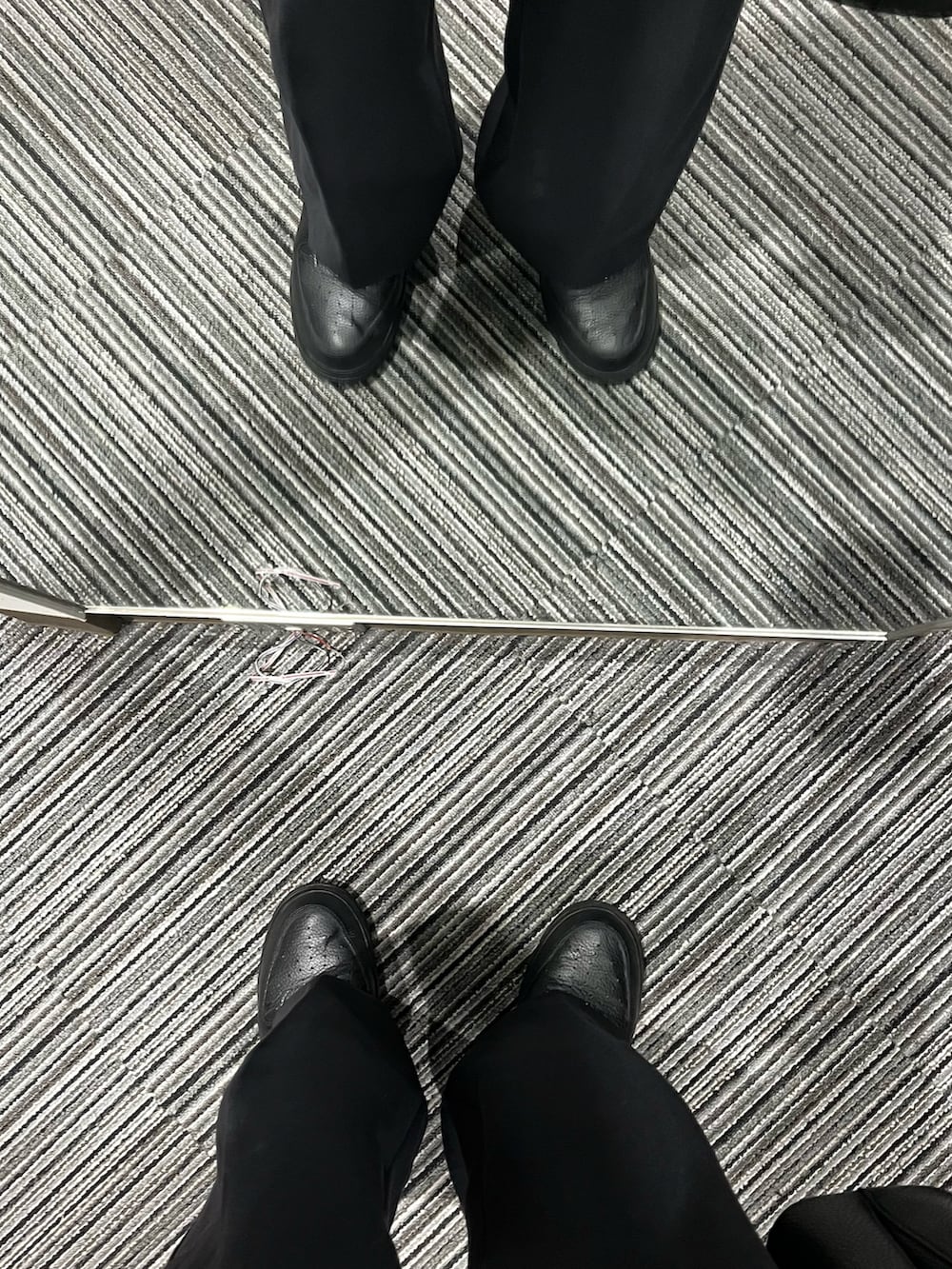 ブラック系のスニーカー、ブラック系のパンツ、ブラック系のショルダーバッグを着用したメンズの冬コーディネートの5枚目の写真