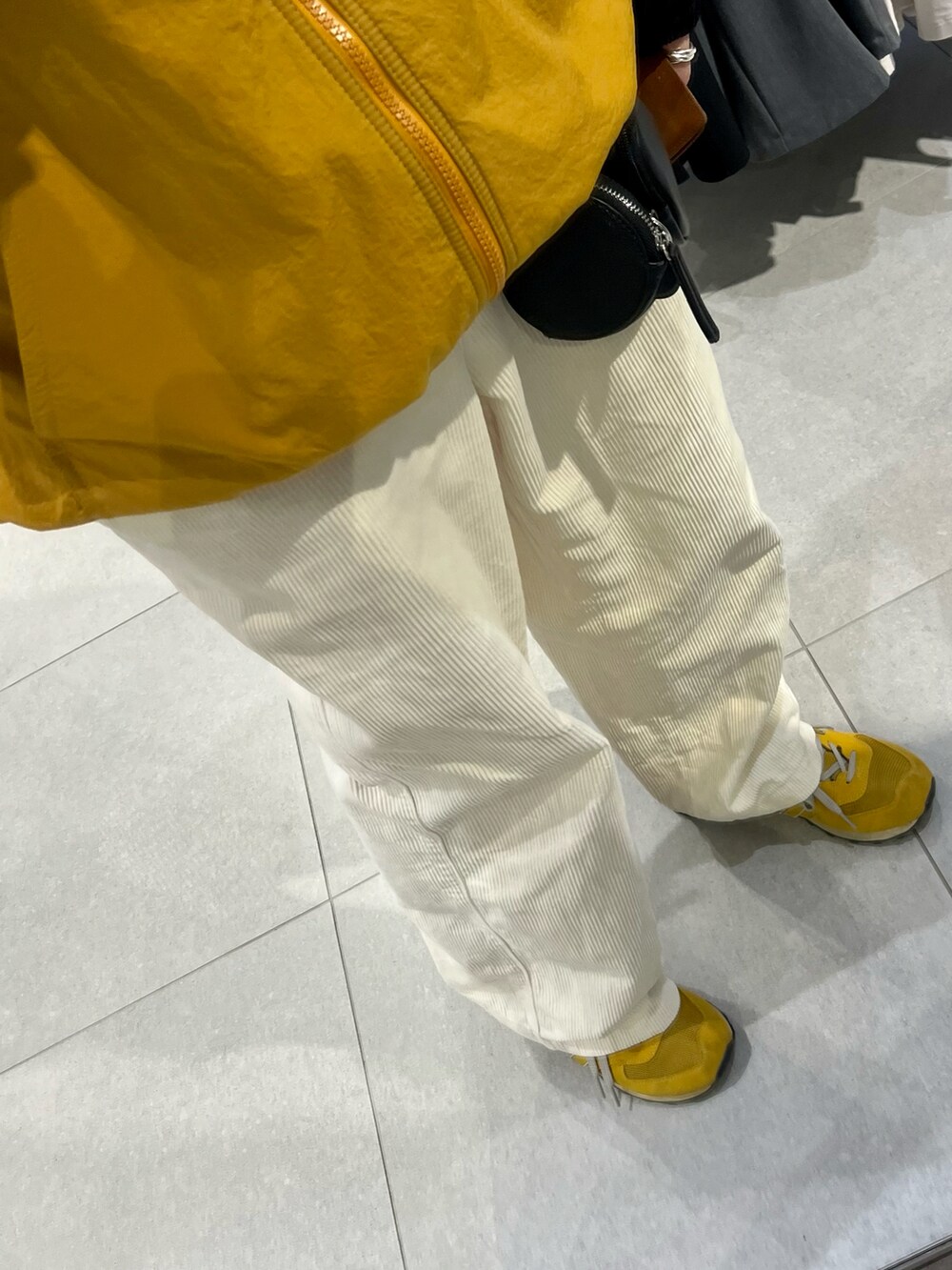 イエロー系のスニーカー、ホワイト系のパンツ、ブルー系のナイロンジャケットを着用したメンズの冬コーディネートの3枚目の写真