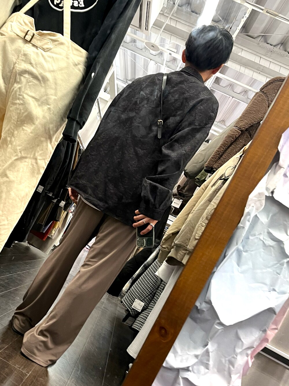 ブラウン系のパンツ、ブラック系のスニーカー、ブラック系のシャツ/ブラウスを着用したメンズの秋コーディネートの2枚目の写真