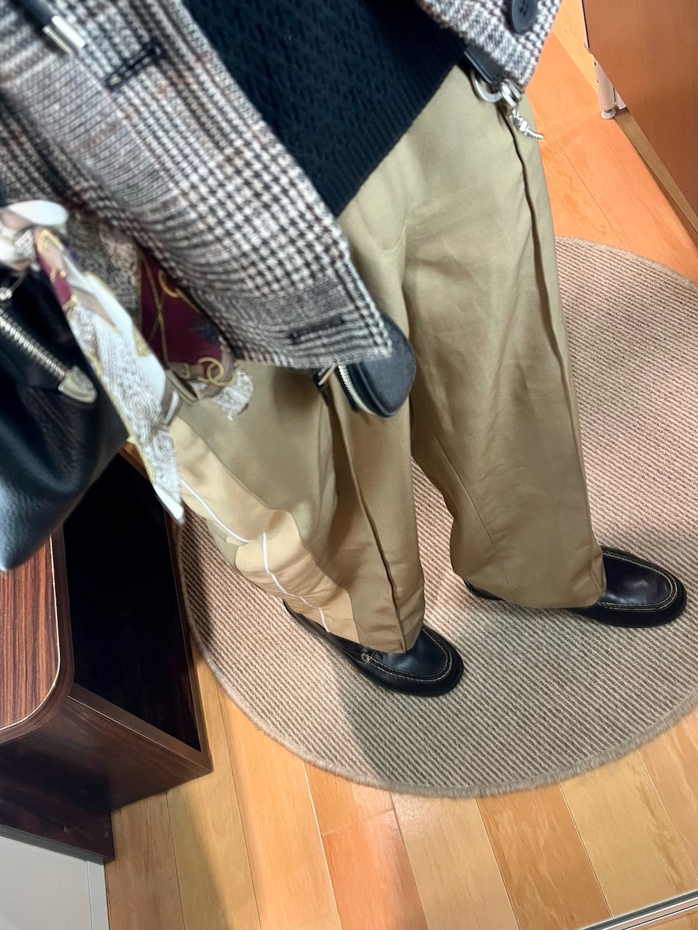 ベージュ系のパンツ、ブラック系のローファー、ブラック系のショルダーバッグを着用したメンズの冬コーディネートの3枚目の写真