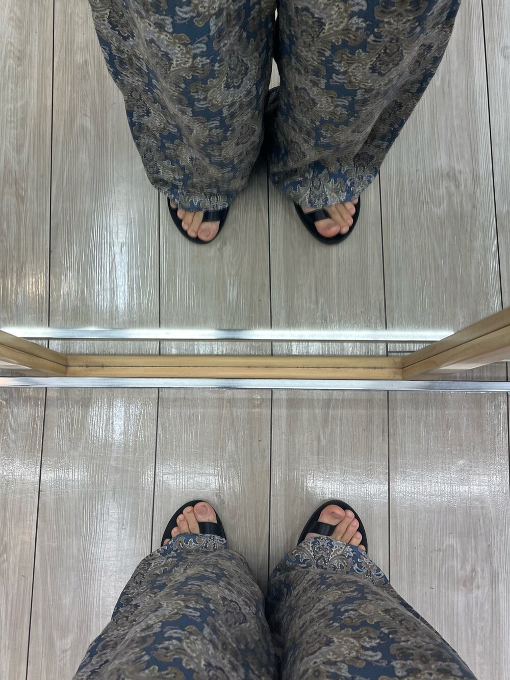 ブルー系のパンツ、ブラック系のサンダル、ブラック系のショルダーバッグを着用したメンズの夏コーディネートの5枚目の写真