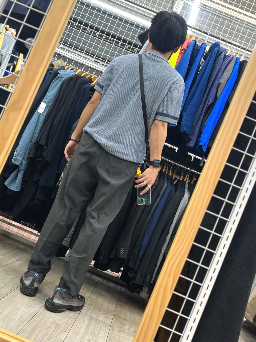ブラック系のパンツ、ブラック系のスニーカー、ブルー系のポロシャツを着用したメンズの秋コーディネートの2枚目の写真