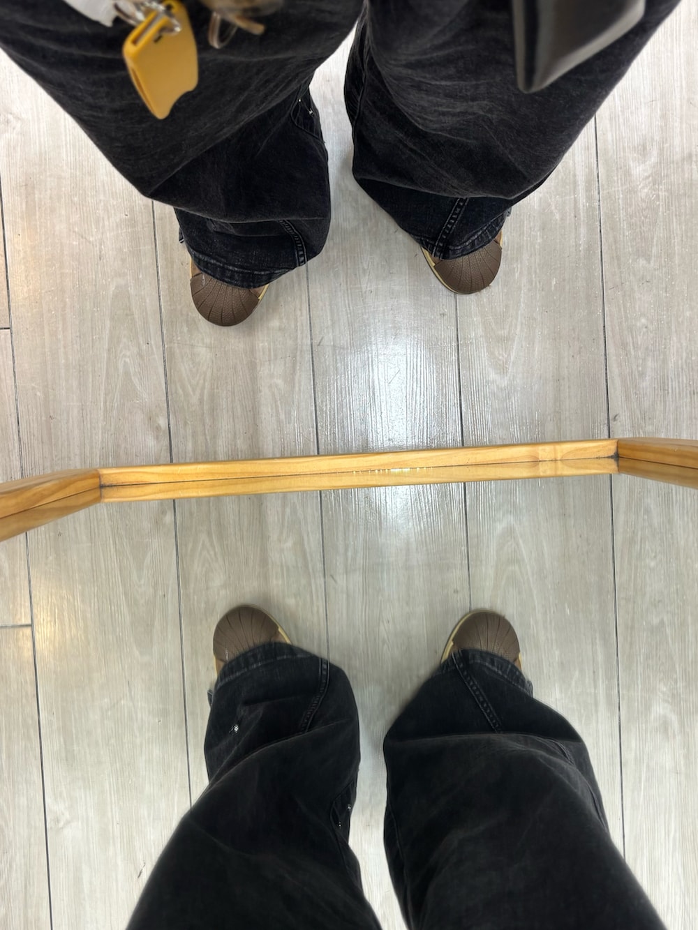 ブラウン系のスウェット、ブルー系のカーディガン/ボレロ、ブラック系のデニムパンツを着用したメンズの春コーディネートの5枚目の写真