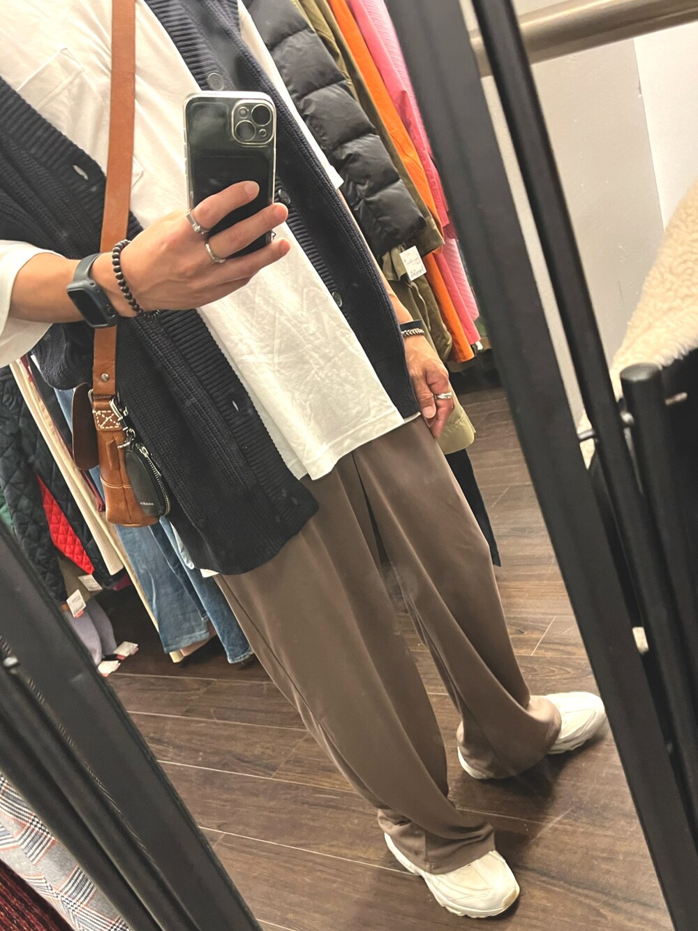 ホワイト系のスニーカー、ブラウン系のパンツ、ブルー系のベストを着用したメンズの秋コーディネートの3枚目の写真